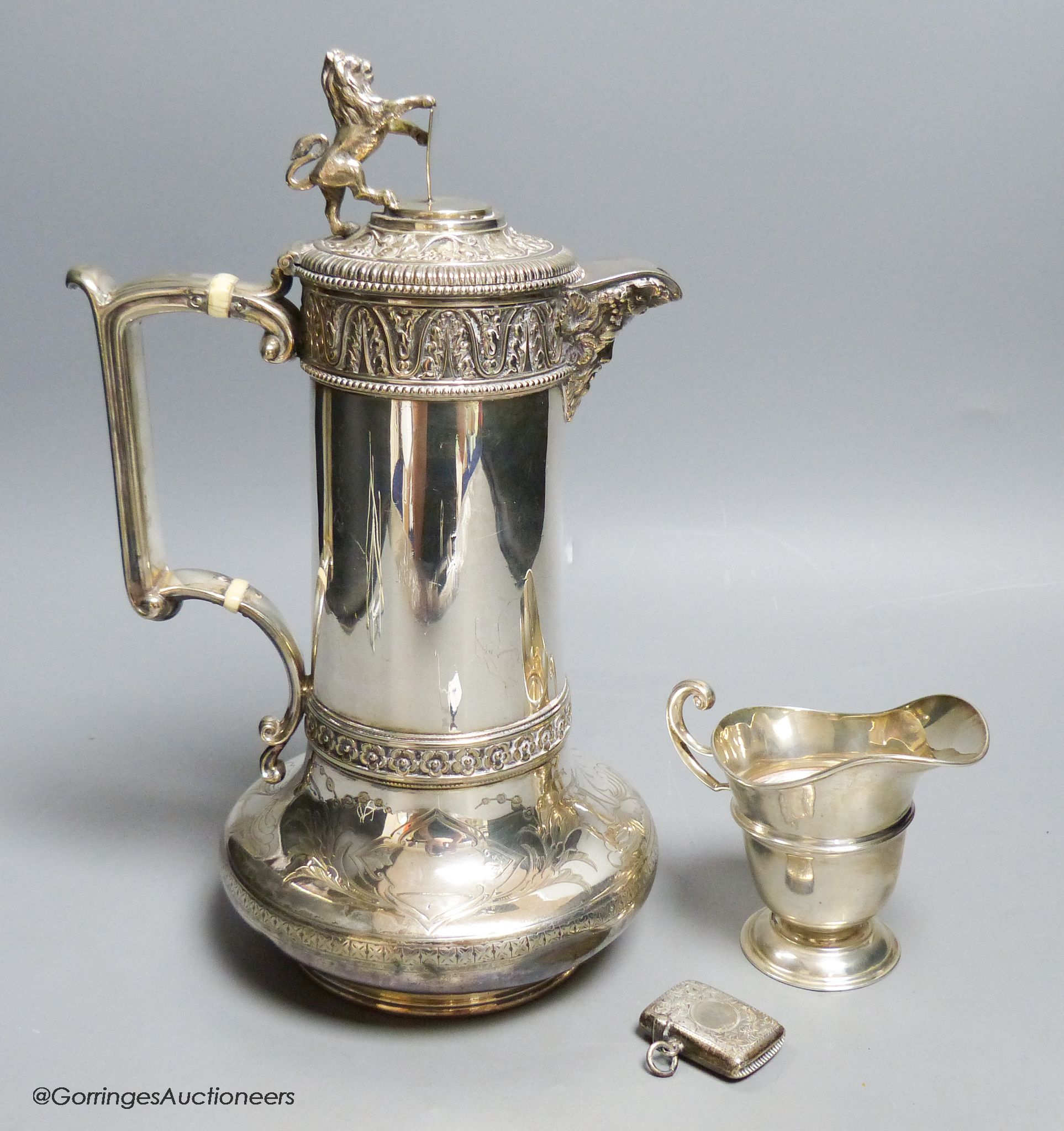 A Victorian Elkington & Co silver plated hot water jug, 27.7cm, an Edwardian silver cream jug and similar silver vesta case.